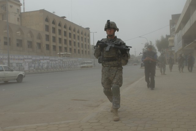 BAGHDAD - Spc. Zachery Hughes, a team leader assigned to Troop B, 5th Squadron, 73rd Cavalry Regiment, 3rd Brigade Combat Team, 82nd Airborne Division, and Ali Falaha, an Iraqi policeman, brave the dusty and dangerous conditions of the Rusafa...