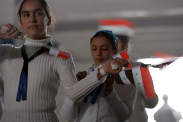 BAGHDAD - Iraqi girls sing the Iraqi National Anthem for a graduation ceremony while Soldiers from the Special Troops Battalion, 1st Infantry Division, secure the area March 5 at the Adl Sports Center in Kadamiyah. Iraqi students from a heavy...