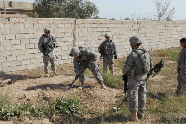 KEM, Iraq — Soldiers of Company A, 1st Battalion, 111th Infantry, 56th Stryker Brigade Combat Team, 28th Infantry Division, and the brigade’s 856th Engineer Company search an area near Kem village March 3 after sweeping the ground with metal detector...
