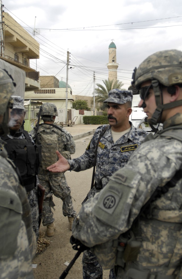 BAGHDAD - First Sgt. Nagim Abud Kanbar (center), 2nd Battalion, 7th Brigade, 2nd National Police Division,  talks with Russia, Ohio native, 1st Lt. Chris Timmerman (right), of the 1st Battalion, 505th Parachute Infantry Regiment, 3rd Brigade...