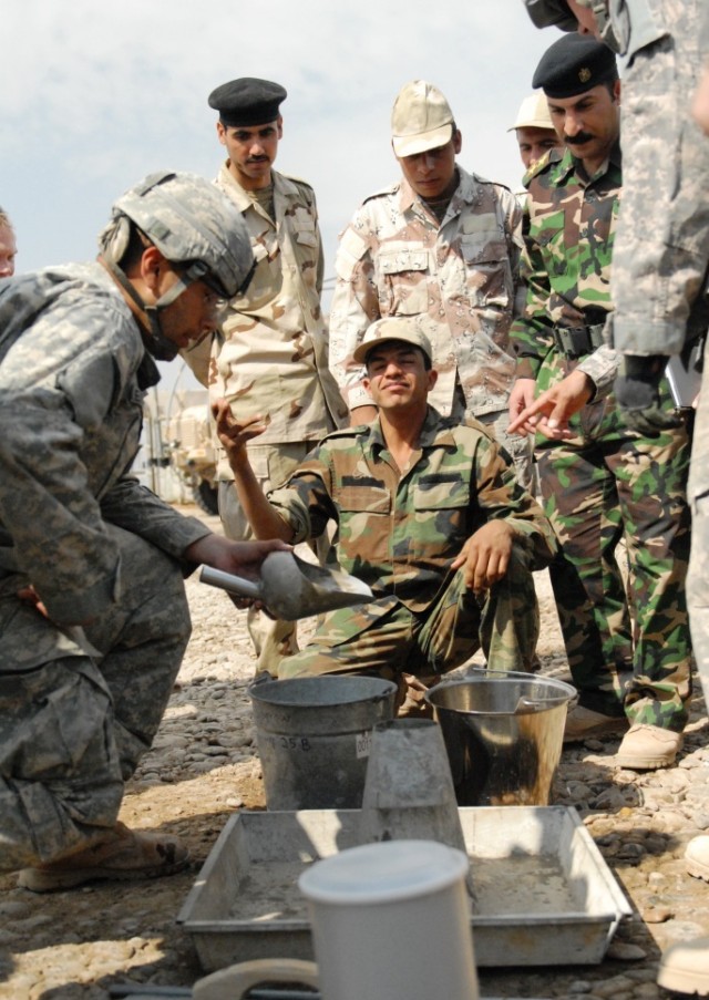Pfc. Jacob Hester (left), of San Jose, Calif., an engineer with the 225th Engineer Brigade, demonstrates the field 'slump' test for concrete to engineers from the 6th Iraqi Army Engineer Regiment, March 4, at Al Muthana Airfield, Baghdad. Hester expl...