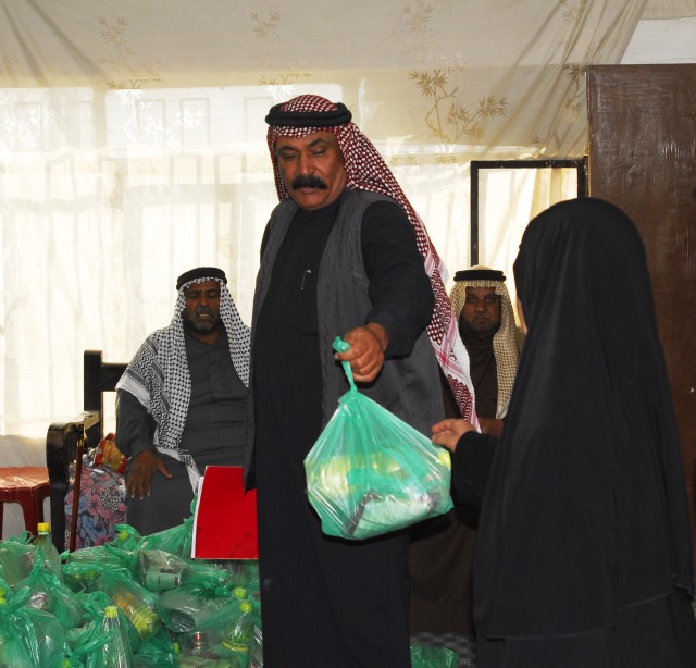 BAGHDAD - Sheik Abed Ali Mansor, Jari city council chairman, passes out humanitarian aid supplies to families of the Radwaniyah region in Jari March 6. Multi-National Division-Baghdad Soldiers assisted local sheiks in conducting the humanitarian...