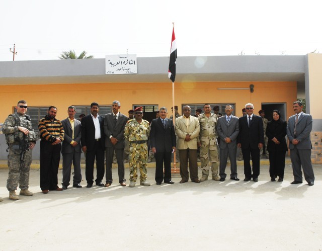 Capt. Landgrave Smith (far left), commander, Company D, 1st Combined Arms Battalion, 63rd Armor Regiment, poses for a photo with members of the Nahia Qada council, Staff Col. Wissam Abidul Razaq, members of Ministry of Education, and Althaira...
