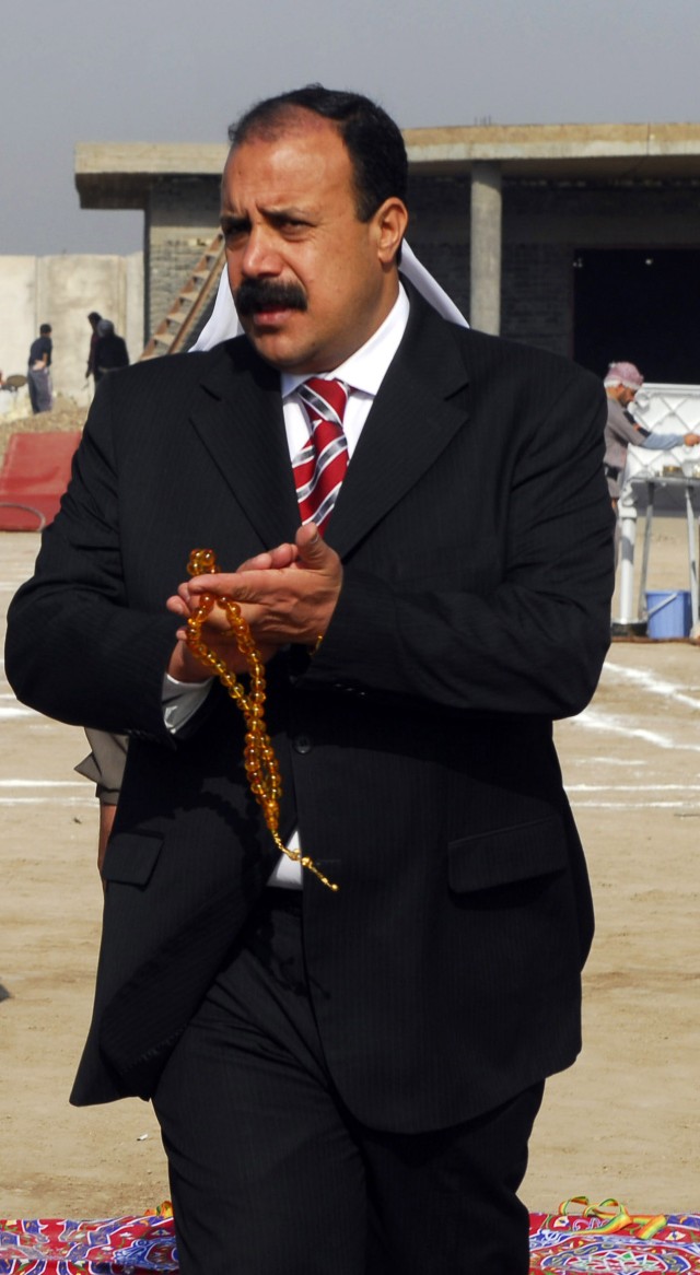 BAGHDAD - Sheik Ayad walks in front of the Farmer's Association building during a ceremony held to celebrate the donation of 20 new tractors to the association on March 6. The tractors were part of an MND-B project to assist the Radwiniyah farmers...