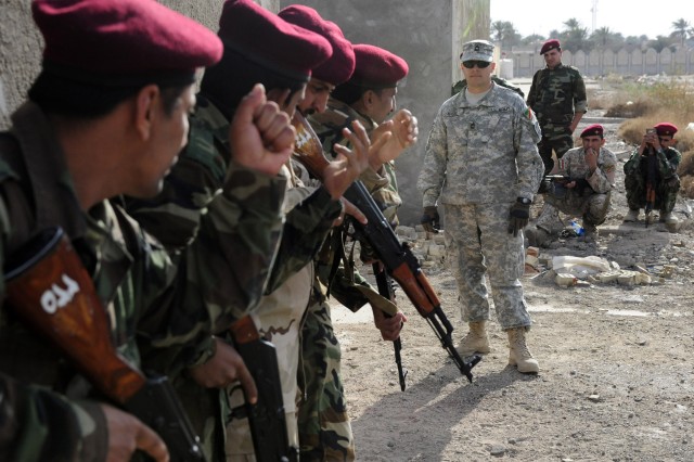 Iraqi Soldiers from the 6th Iraqi Army Division, Intelligence, Surveillance and Reconnaissance Battalion, practice the use of hand signals while entering and clearing buildings under the direction of Master Sgt. Robert Eplee, a native of Brevard,...