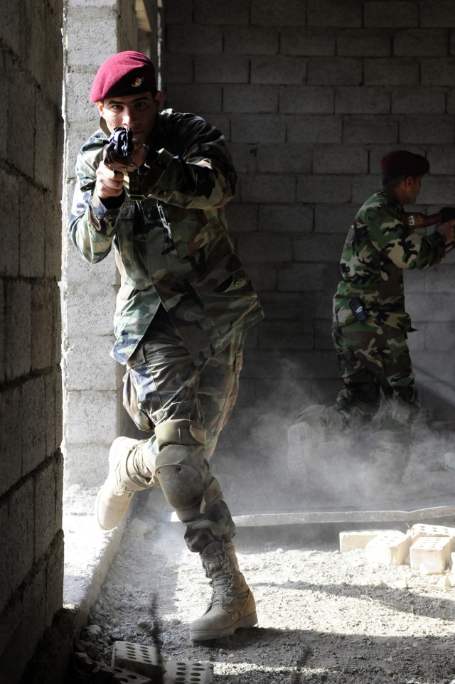 An Iraqi Soldier with the 6th Iraqi Army Division, Intelligence, Surveillance and Reconnaissance Battalion, searches for his target while conducting a simulated building raid during Military Operations Urban Terrain Training, March 2, at Muthana...