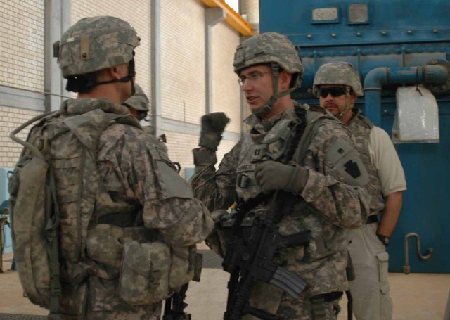 TARMIYAH, Iraq - Tucson, Ariz. native Capt. Phil Benner (right), assistant brigade engineer for 56th Stryker Brigade Combat Team, 28th Infantry Division, Multi-National Division-Baghdad, explains to a Soldier what needs to be done to make a pump oper...
