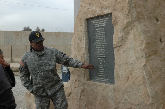 Charlie Wilson, solo recording artist and lead singer of Charlie Wilson and the Gap Band, pauses to take a closer look at the names of the fallen heroes listed on a memorial stone located outside of the dining facility on Forward Operating Base...