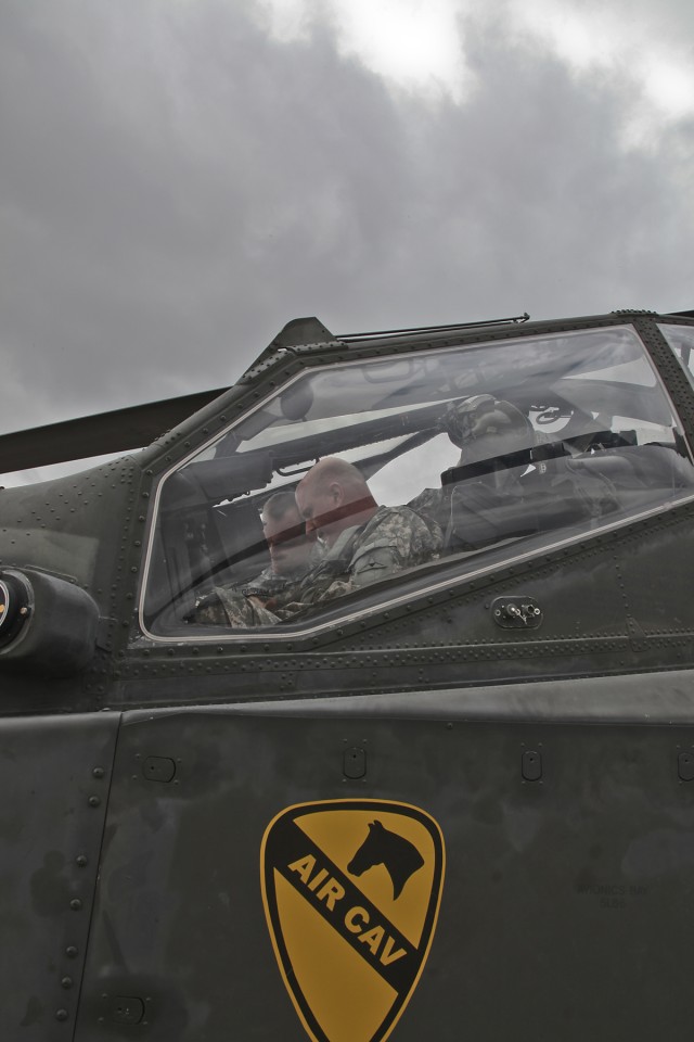During the pre-flight of an AH-64D Apache attack Helicopter, Command Sergeant Major Neil Ciotola, command sergeant major of III Corps, gets strapped in the front seat as he prepares to get a ride in the helicopter, Fort Hood, Texas, March 9. The...