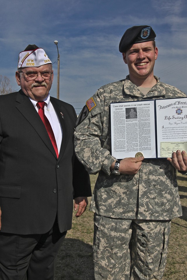 Specialist Ryan Frushour, of Denver, a UH-60 Black Hawk Helicopter crew chief in Company B, 3rd Assault Helicopter Battalion, 227th Aviation Regiment, 1st Air Cavalry Brigade, 1st Cavalry Division, received an award from Harry Munn, of Hewitt,...