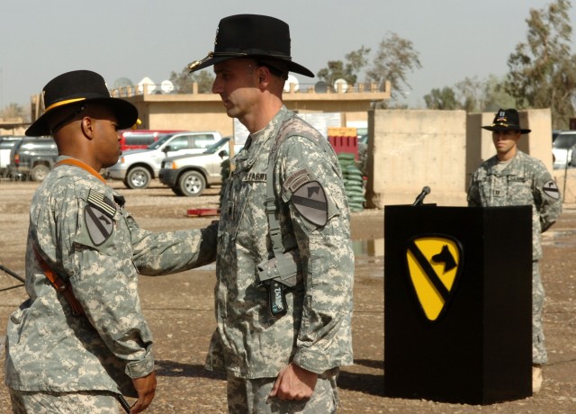 CAMP LIBERTY, Iraq - Command Sgt. Maj. Clinton L. Joseph (left), senior enlisted leader, Division Special Troops Battalion, 1st Cavalry Division, presents the First Team combat patch to Lt. Col. Matthew Karres, commander, Division Special Troops Batt...
