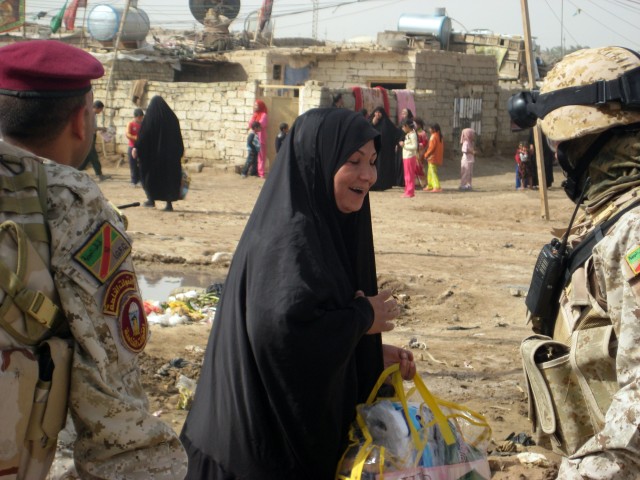 An Iraqi woman from the Hay Al Hussein neighborhood of Al Amarah, Iraq, thanks an Iraqi Army Soldier, assigned to the 1st Battalion, 40th Iraqi Army Brigade, for a bag filled with bedding supplies and food handed out during a humanitarian aid drop Ma...