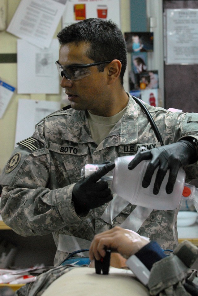 CAMP LIBERTY, Iraq -Amid the beeps of medical monitoring equipment and the barking of orders, Sgt. Sergio Soto, from Lafayette, Colo., 299th Brigade Support Battalion, 1st Infantry Division,, stays focused on his monitor and prepares a bag valve...