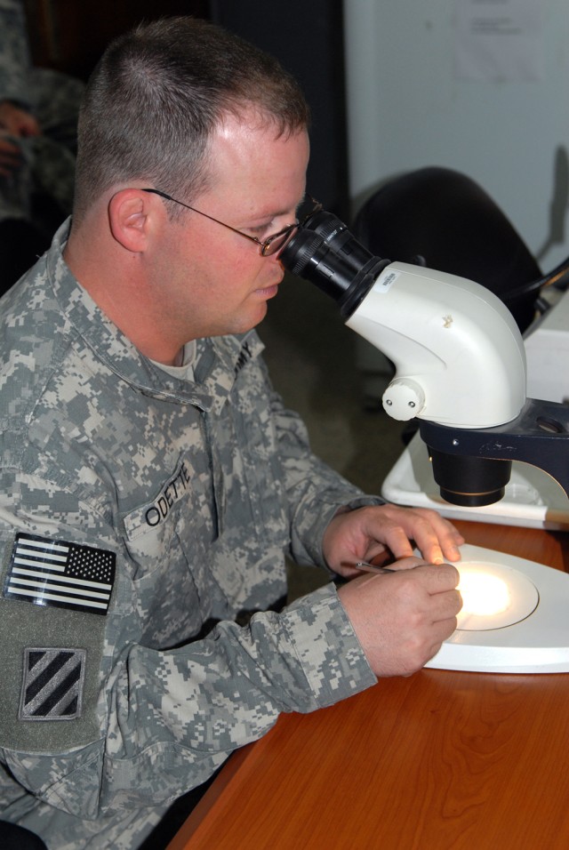 VICTORY BASE COMPLEX, Iraq - Denver native, Staff Sgt. Seth Odette, 1848th Medical Detachment's preventative medicine section, inspects an insect under a dissection microscope. Any mosquitoes and sand flies he identifies will be sent off to U.S. Army...