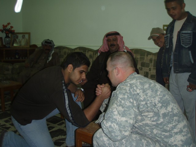 TAJI, Iraq - Sgt. Frank DuBeck (right), 2nd Battalion, 104th Cavalry Squadron, 56th Stryker Brigade Combat Team, accepts an arm wrestling challenge from the son of a local Iraqi Sheik. The Harrisburg, Pa. native discovered that diplomacy comes in...