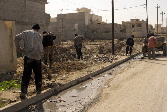 A group of men that live in 7 Nissan, a neighborhood in northern Mosul, shovel the trash that has accumulated in empty lots and along curbsides. 7 Nissan and many neighborhoods in Mosul are part of a series of projects devoted to cleaning the city's ...