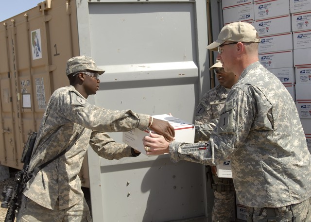 BAGHDAD - Col. Joseph Martin (right), commander, 2nd Heavy Brigade Combat Team 'Dagger," 1st Infantry Division, Multi-National Division - Baghdad, who hails from Dearborn, Mich., hands a care-package to Beaufort, S.C. native Pfc. Joseph Jacques...