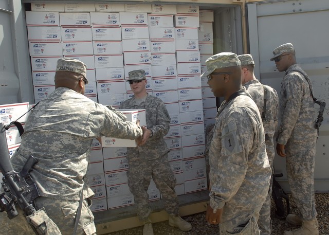 BAGHDAD - Soldiers serving with the 2nd Heavy Brigade Combat Team 'Dagger," 1st Infantry Division, Multi-National Division - Baghdad unload care-packages from a storage container at Camp Liberty March 12. Volunteers in Washington state from the...