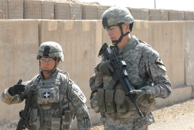 BAGHDAD - Staff Sgt. Jessica Harris (left), an entry control point (ECP) non-commissioned officer in charge serving with Troop C, 1st Squadron 303rd Cavalry Regiment, attached to 1st Sqdn. 124th Cav. Regt., explains ECP operation to Maj. Gen. Daniel ...