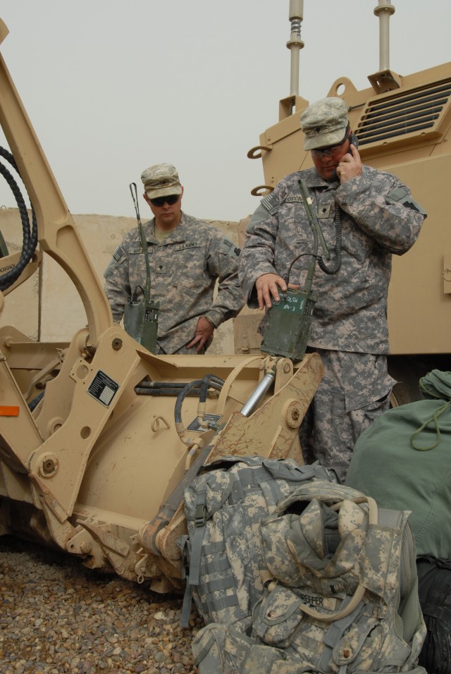 CAMP TAJI, Iraq - Spc. George Keifer (left), of Bethel, Pa., a Soldier with the 856th Engineer Company, and Spc. Preston O'Connor, of Allentown, Pa., a Soldier with Company C, 1st Battalion, 111th Infantry Regiment, check radios in preparation to...