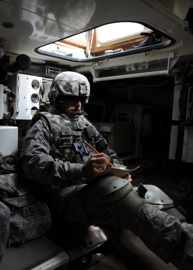 CAMP TAJI, Iraq - Sgt. 1st Class James Mergott, of Ridley, Pa., a platoon sergeant with Company C, 1st Battalion, 111th Infantry Regiment, 56th Stryker Brigade Combat Team, reviews a manning roster in the rear of a Stryker vehicle at Joint Security S...