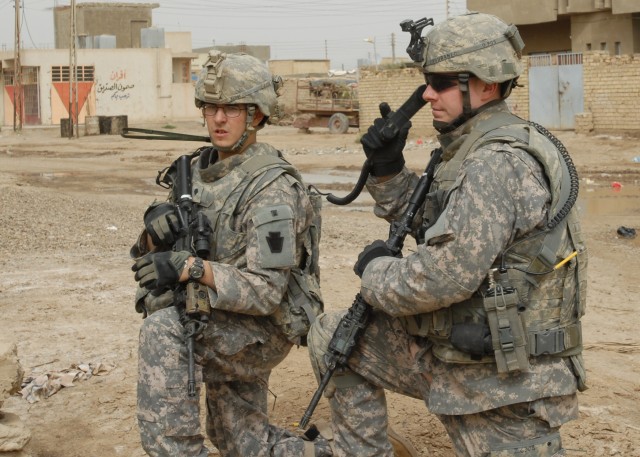 CAMP TAJI, Iraq - Spc. John Kohr (left) of Port Clinton, Pa., pulls security while 1st Lt. Steven Zahuranec of Plymouth Meeting, Pa., talks to other elements participating in a patrol in Al-Faris, southwest of Tarmiyah, Friday, March 13. The Soldiers...