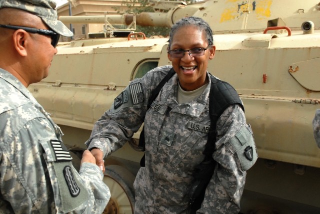 BAGHDAD -Sgt. Verna Oates (right), with Headquarters and Headquarters Company, 56th Infantry Brigade Combat Team, 36th Infantry Division, Multi-National Division-Baghdad, receives a congratulatory handshake from 1st Sgt. Ron Novio, senior enlisted le...