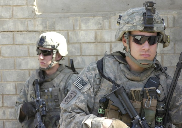 BAGHDAD - Paratroopers assigned to Troop C, 5th Squadron, 73rd Cavalry Regiment, provide outer security as National Police officers assigned to the 3rd Battalion, 8th NP Brigade, 2nd NP Division inspect a near-by house during an Iraqi-led...