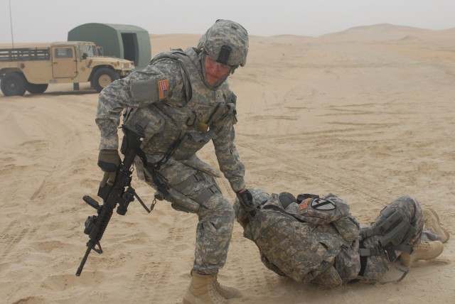CAMP BUERHING, Kuwait - Detroit, Mich. Native, Pvt. Matthew Osborne, a gunner from 1st Brigade Special Troops Battalion, 1st Brigade Combat Team, 1st Cavalry Division, drags a "wounded" troop to an established casualty collection point to further ass...