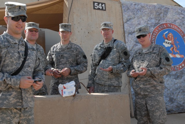 CAMP TAJI, Iraq - Spc. Michael Frost (second from right), of New Castle, Pa., a Soldier with Headquarters and Headquarters Company, 56th Stryker Brigade Combat Team, 28th Infantry Division, began distributing a bag of "Dog Tags for Kids" keepsakes to...