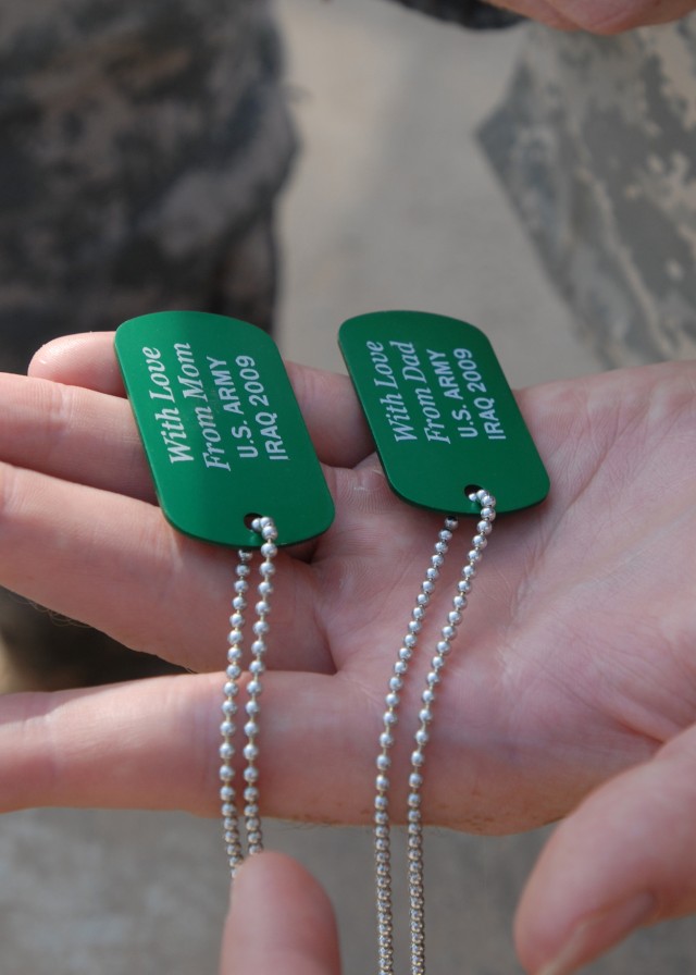 CAMP TAJI, Iraq - These Army green "dog tags" read "With Love from Dad or from Mom, U.S. Army, Iraq, 2009." The Dog Tags for Kids organization reports on its Web site that 420,000 of the tags have been distributed to deployed Soldiers, at no cost to ...