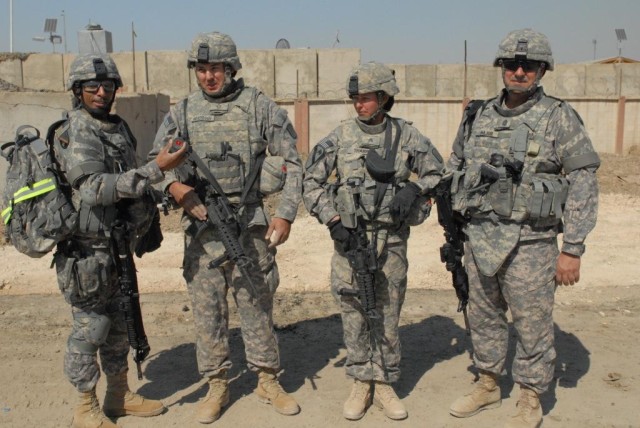 BAGHDAD - Brig. Gen. Owen Monconduit (far left), commander of the 225th Engineer Brigade, 1st Cavalry Division, Multi-National Division-Baghdad stands with Command Sgt. Maj. Joe Major (far right) to present his coin of excellence to Pfc. Jason Bradsh...