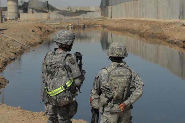 BAGHDAD - Pineville, La. native, Brig. Gen. Owen Monconduit (left), commander, 225th Engineer Brigade, and 1st Lt. Kewanda Tate of Company A, 46th Eng. Battalion, who hails from Tuscaloosa, Ala., discuss the newly completed drainage pond March 17...
