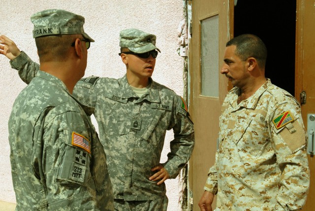 BAGHDAD – Master Sgt. Michael Eddy (center), non-commissioned officer in charge, Team Weasel, 6th IA Div. MiTT, speaks with Sgt. Major Ayad Mohammed Ali Jassem, Intelligence, Surveillance and Reconnaissance Battalion, 6th ID Div. with the help of an ...