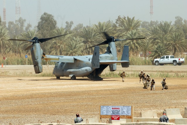 CAMP LIBERTY, Iraq - Marines (right) exit from the back of a MV-22B Osprey, a multi-mission, military tilt-rotor aircraft, at Camp Liberty March 19. Osprey aircraft routinely transport Marines, their supplies and equipment throughout the theater...