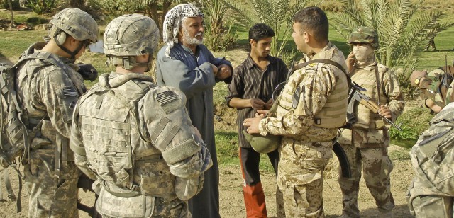 A village leader pockets an information card given to him by an Iraqi platoon leader March 7. The 41st Iraqi Army Brigade partners with Soldiers from the 5th Battalion, 82nd Field Artillery Battalion, 4th Brigade Combat Team, 1st Cavalry Division...