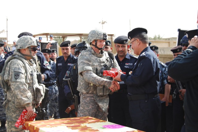 BAGHDAD - In recognition of efforts advancing Iraqi Police development, Brig. Gen. Ali Adnan Younis (right), Provincial Director of Police (PDoP), presents Chicago native 1st Lt. Robert Conner, 267th Military Police Company, 93rd MP Battalion, 8th...