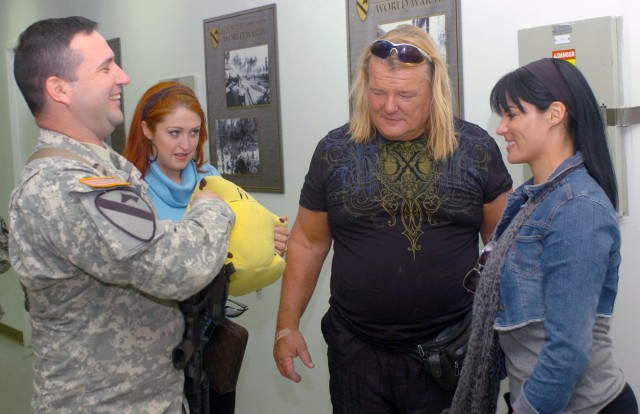CAMP LIBERTY, Iraq - Wrestling stars, So Cal Val (second from left), Greg "The Hammer" Valentine (second from right) and Traci Brooks (right) talk with Sgt. 1st Class Raoul Rodriguez, a provost marshal office operations noncommissioned officer,...
