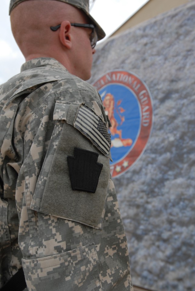 CAMP TAJI, Iraq - Wearing his "Keystone" combat patch for the first time, Spc. Joseph Ginder of Philadelphia, Headquarters and Headquarters Company, 1st Battalion, 111th Infantry Regiment, 56th Stryker Brigade Combat Team, stands in front of the Penn...