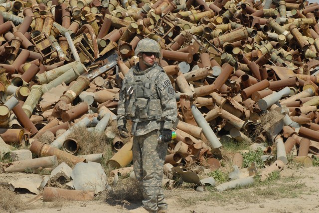 Sgt. Robert Solesbee, a native of Corona, Calif., assigned to 710th Explosive Ordnance Disposal Company, 3rd Ordnance Battalion, 71st Ordnance Group, glances around at his surroundings, looking for potentially dangerous ordnance among the scrap...