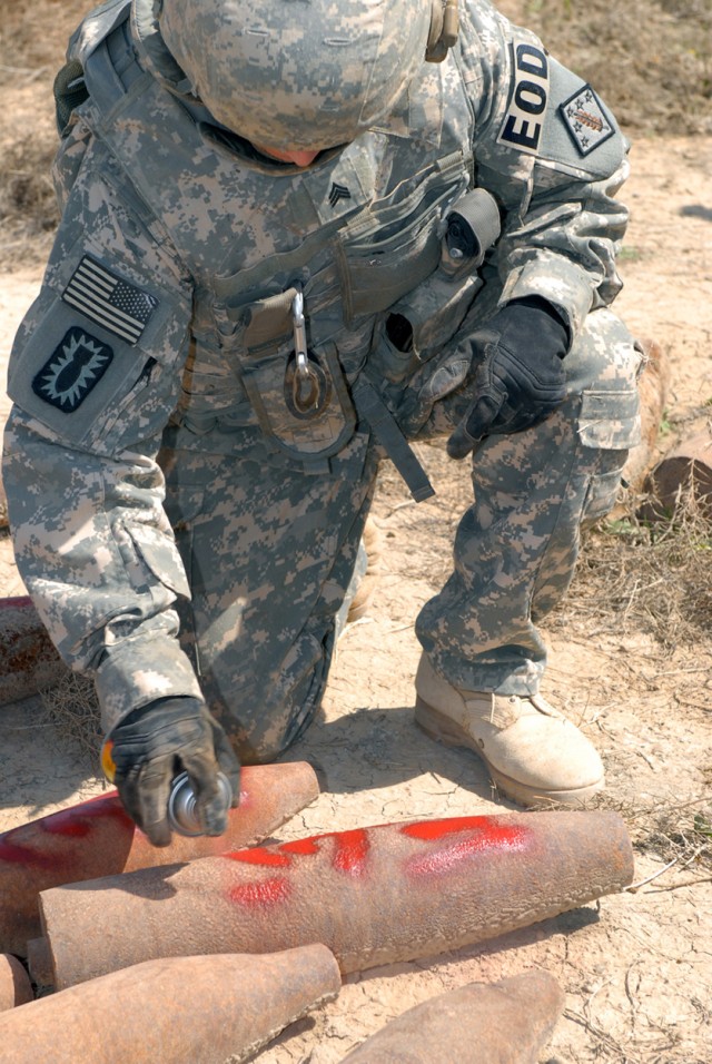 CAMP TAJI, Iraq - Sgt. Robert Solesbee, assigned to 710th Explosive Ordnance Disposal Company, 3rd Ordnance Battalion, 71st Ordnance Group, a native of Corona, Calif., marks unexploded ordnance at the Sheik Khalid scrap yard March 18. His team was...