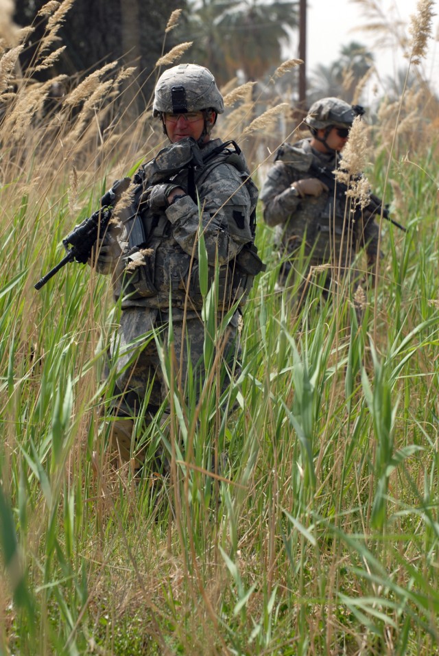 New Blomfield, Pa. native, Staff Sgt. Ronald Chunn (left), and Pvt. 1st Class Zakaria Rehawi, both assigned to 2nd Battalion "Strykers," 112th Infantry Regiment, 2nd Brigade Combat Team, 1st Infantry Division, search a field at the Baghdad...
