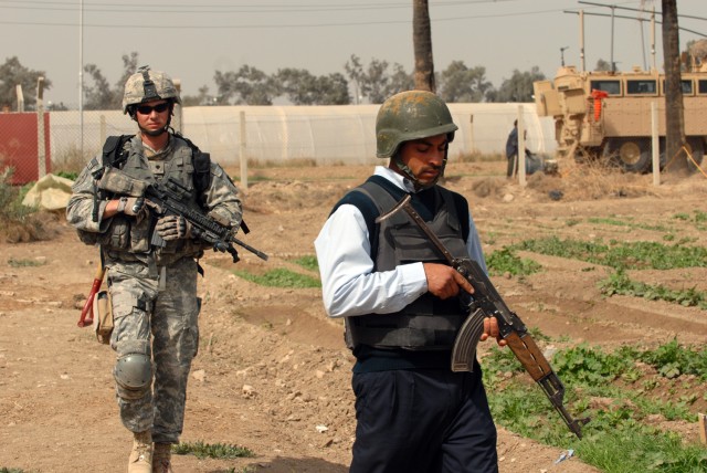 Spc. Dane Bamford (left), from Shamokin, Pa., assigned to the 2nd Battalion, 112th Infantry Regiment, 2nd Brigade Combat Team, 1st Infantry Division, searches with an Iraqi policeman during a joint operation at Baghdad University College of Agricultu...