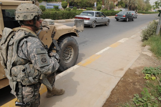 BAGHDAD - Capt. Andy Hercik, commander, Battery A, 1st Battalion, 319th  Airborne Field Artillery Regiment, takes a knee next to his humvee during an Coalition forces visit to an Iraqi Security Forces checkpoint March 20 in the Al Karradah...