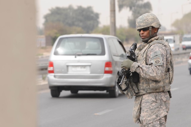 BAGHDAD - Fayetteville, N.C. Sgt. 1st Class Sherwood McClinton of Battery A, 1st Battalion, 319th  Airborne Field Artillery Regiment, provides security near a checkpoint March 20 in the Al Karradah district of eastern Baghdad.  Paratroopers were...