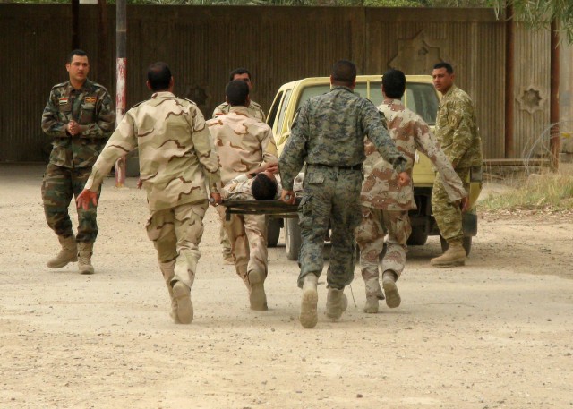 BAGHDAD -Iraqi Soldiers serving with the 22nd Brigade, 6th Iraqi Army Division carry a comrade to evacuation during simulated medical training March 10 on Forward Operating Base Justice. The IA Soldiers worked together with elements of the 299th...