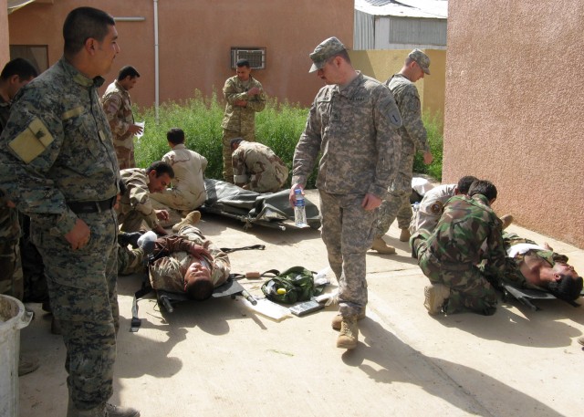 BAGHDAD - Staff Sgt. Derek Lariviere, Company C, 299th Brigade Support Battalion observes as Iraqi Army Soldiers from the 22nd Brigade, 6th Iraqi Army Division treat their counterparts in a simulated medical exercise March 10 at the IA...