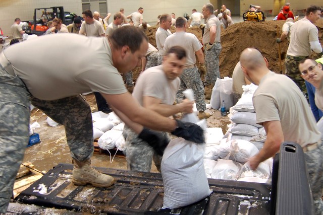 North Dakota National Guard Soldiers and airmen prepare sandbags for the rising waters of the Missouri River and Apple Creek, March 24, 2009. The two bodies of water, which are covered with ice chunks, are converging south of Bismarck, N.D., causing ...