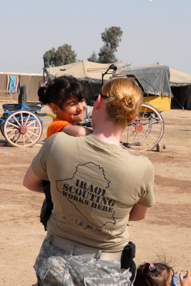 CAMP VICTORY, Iraq - Sgt. Shannon LeMaster, an imagery analyst with the 301st Military Intelligence Battalion, Multi-National Corps - Iraq, welcomes Tabarak, age 4, to another fun-filled day of Iraqi Scouting March 21. LeMaster, a native of Phoenix, ...
