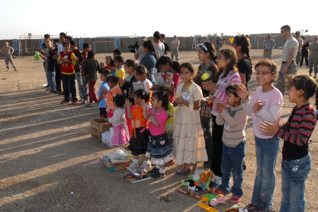 CAMP VICTORY, Iraq - Happy children and volunteer service members line up to celebrate a successful day of scouting activities and fun before beginning the closing ceremony March 21. Each week, the children are exposed to a new scouting lesson, an...